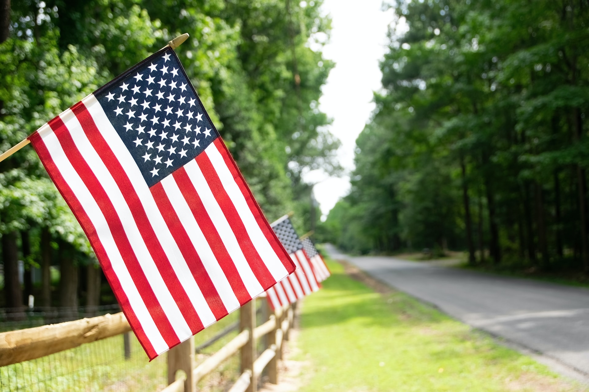 Image of American Flags hanging from a fence