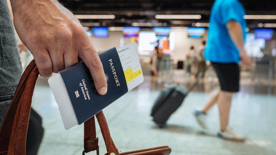 Traveler holding passport and bag