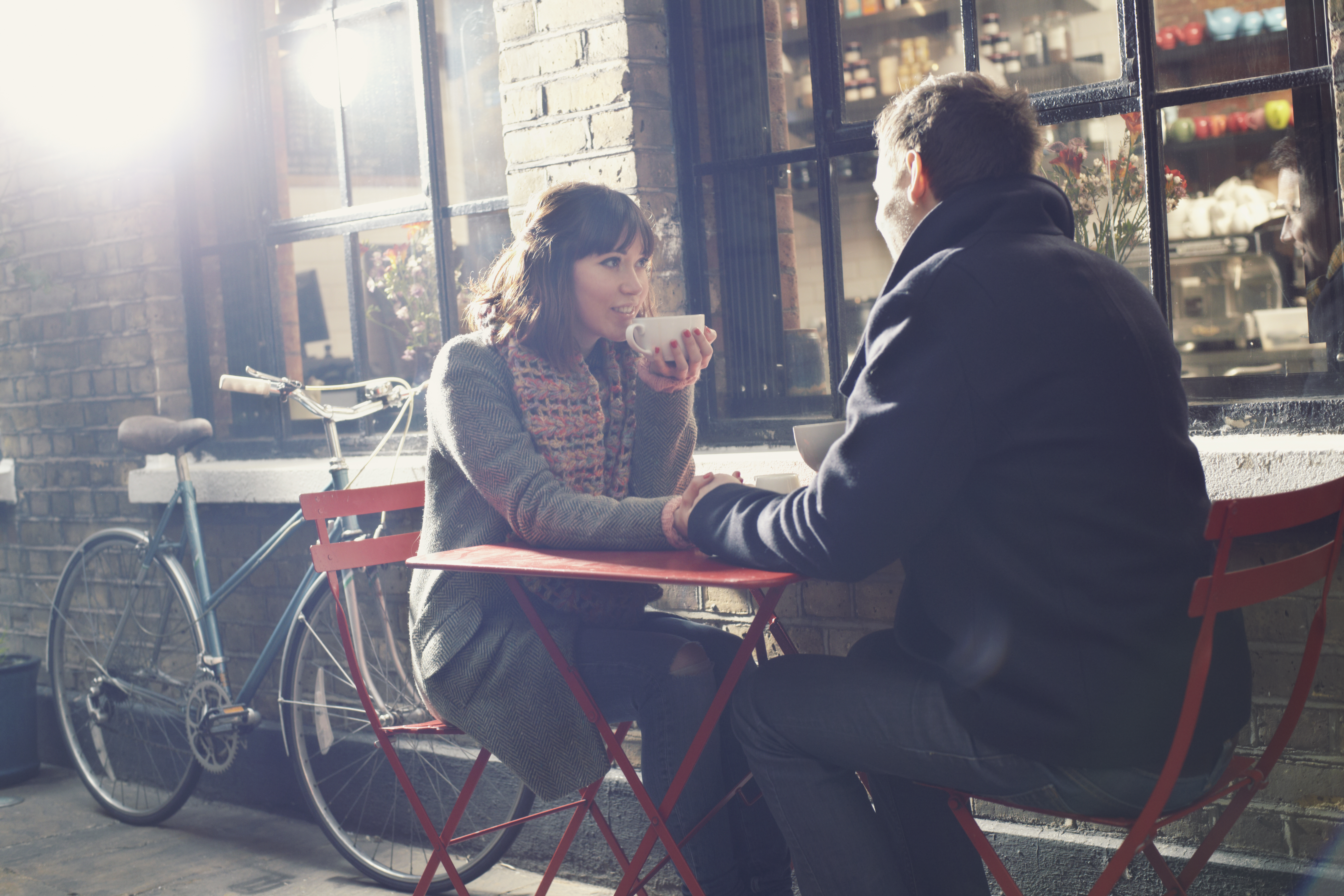woman and man sitting outside at red table