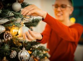 person hanging ornament on tree